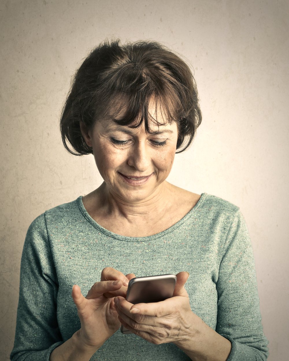 Ältere Dame nutzt entspannt ihr Smartphone – digitale Begleitung durch den Digital Age Concierge